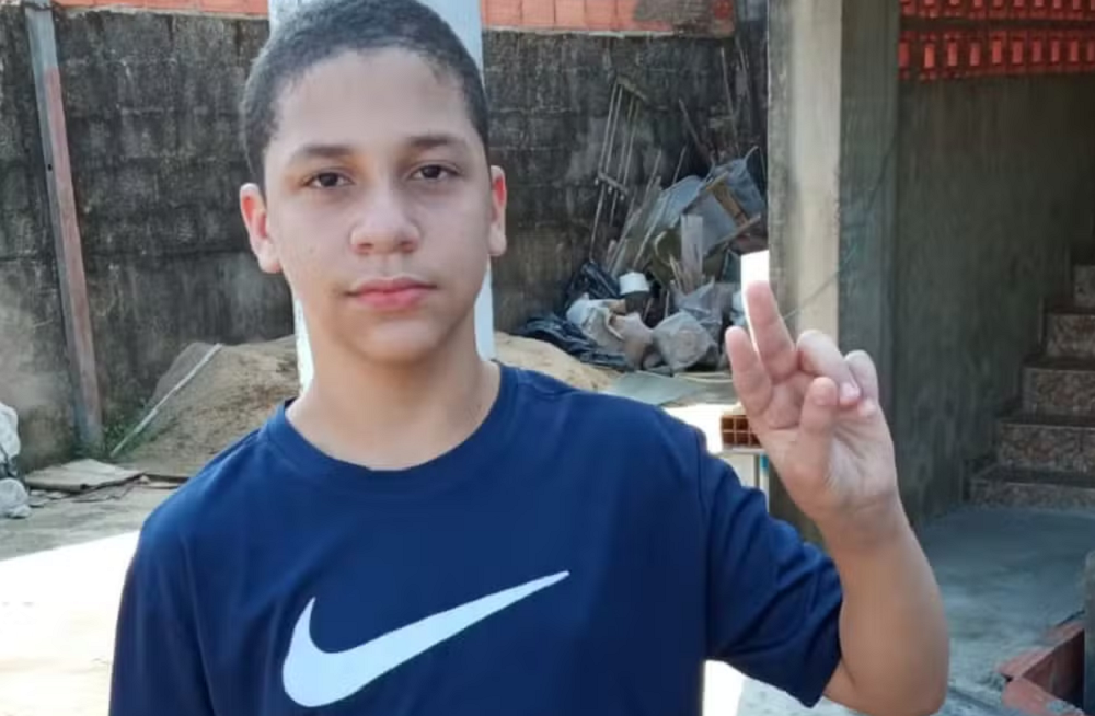 Carlos Teixeira de camiseta azul marinho fazendo sinal de paz e amor