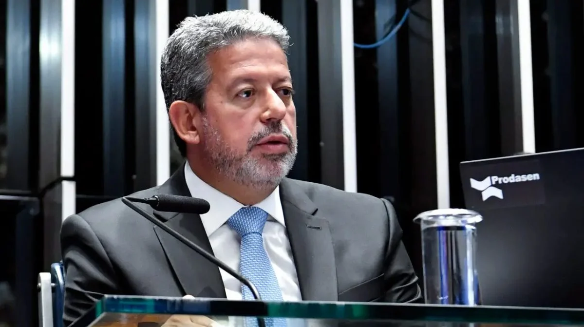 Arthur Lira de terno e gravata, com expressão pensativa, sem olhar para a câmera