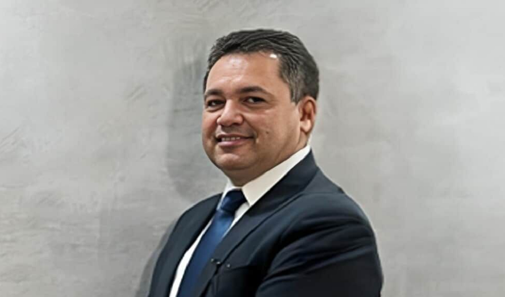 Ruy Rodrigues Santos Filho sorrindo de terno e gravata para foto
