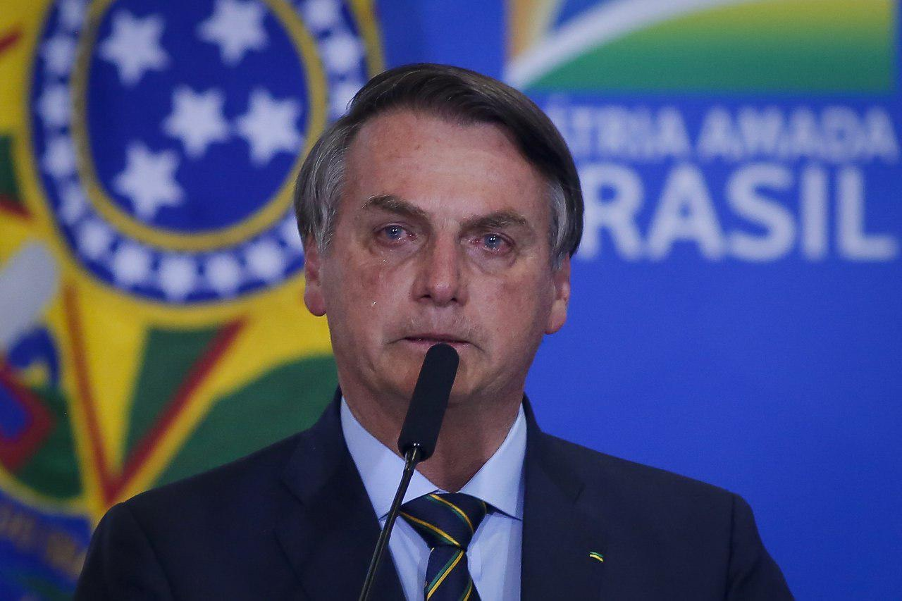 Jair Bolsonaro chorando perto de microfone