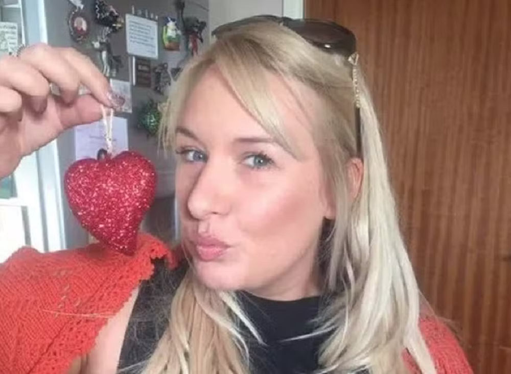 Joanne Dodd de roupa preta e vermelha, fazendo biquinho para foto, com óculos escuros na cabeça