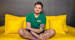 Felipe Neto posando para foto sentado em sofá amarelo