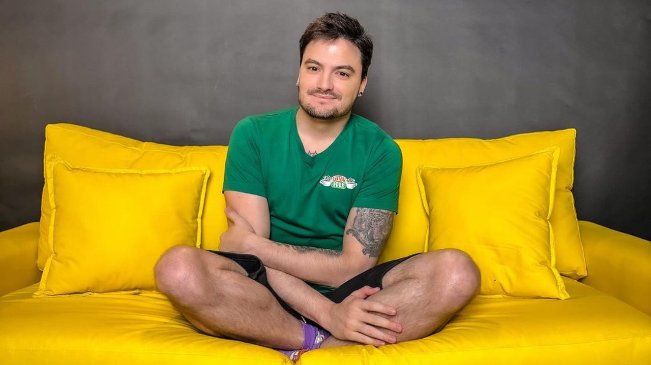 Felipe Neto posando para foto sentado em sofá amarelo