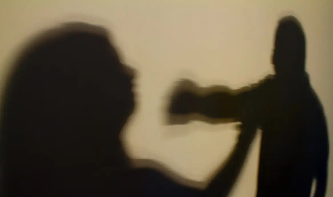 Sombra de mulher tentando se defender de agressão