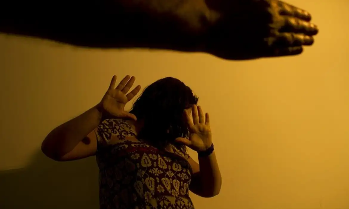 Mulher se protegendo de braço masculino