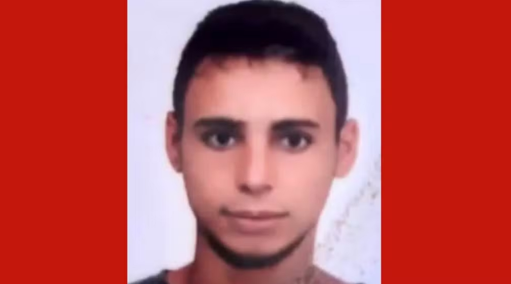 Marcos Roberto Correia da Silva sério em foto no centro de montagem com fundo vermelho