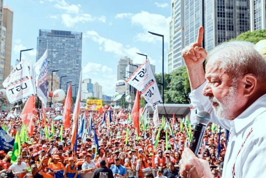 Lula de perfil, falando para multidão, com microfone na mão