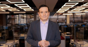 Roberto Cabrini posando para foto em redação, com expressão séria