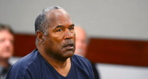 O.J. Simpson com expressão de espanto e roupa azul escura