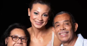 Walewska Oliveira sorrindo entre a mãe e o pai