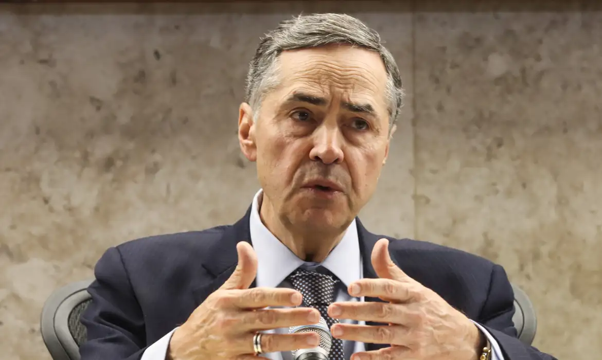 Luís Roberto Barroso falando e gesticulando, sem olhar para a câmera