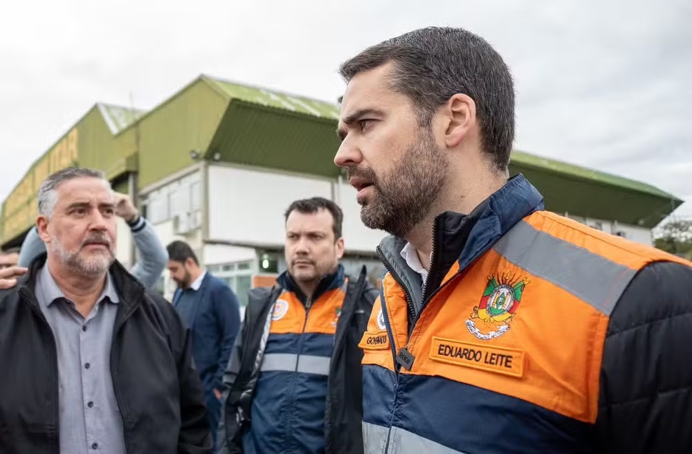 Paulo Pimenta e governador Eduardo Leite, o primeiro sério, olhando pro segundo, que está falando