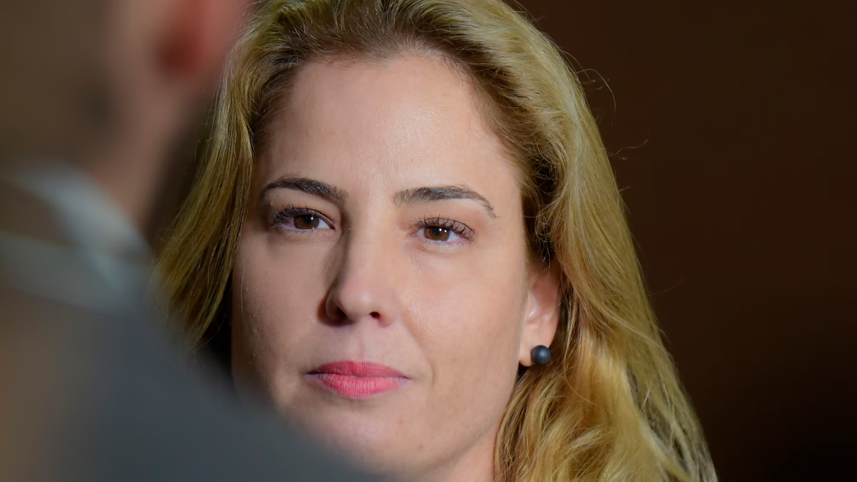 Gabriela Hardt em close, com expressão séria e cabelo solto