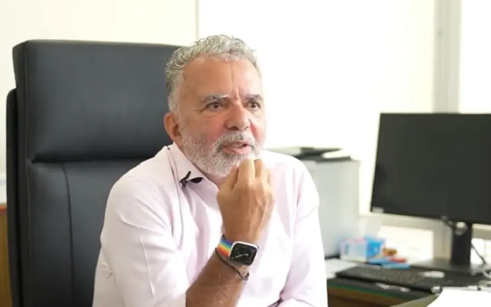 Frederico Meyer, embaixador brasileiro em Israel, de camisa social branca e relógio, falando sem olhar para a câmera com mão direita próxima ao rosto
