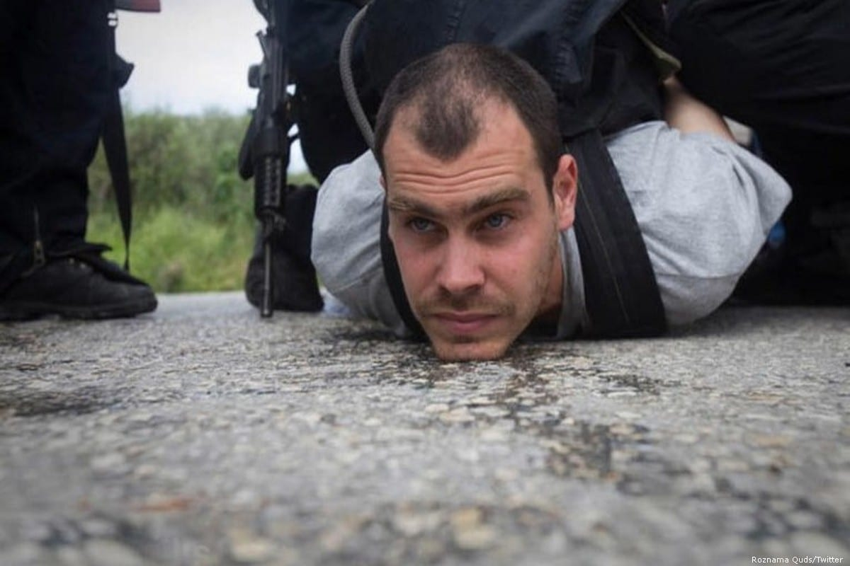 O ativista israelense Jonathan Pollak, no chão, cercado de agentes