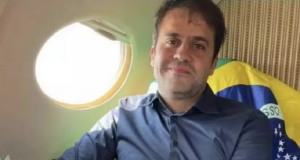 Pablo Marçal perto de janela de avião com bandeira do Brasil ao fundo, sem sorrir