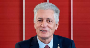 Rogério Correia falando em fundo vermelho
