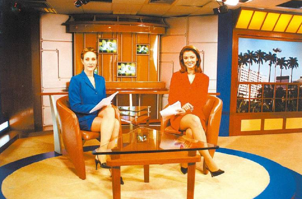 Cynthia Benini e Analice Nicolau em foto antiga, sentadas lado a lado, olhando para a câmera, em cenário 