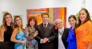 Silvio Santos em foto sorrindo com as filhas e a esposa, todos em pé, lado a lado