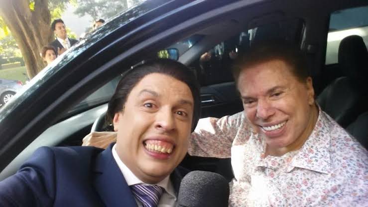 Silvio Santos dentro de carro e Ceará caracterizado sorrindo, do lado de fora