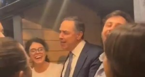Luís Roberto Barroso rodeado de jovens, cantando