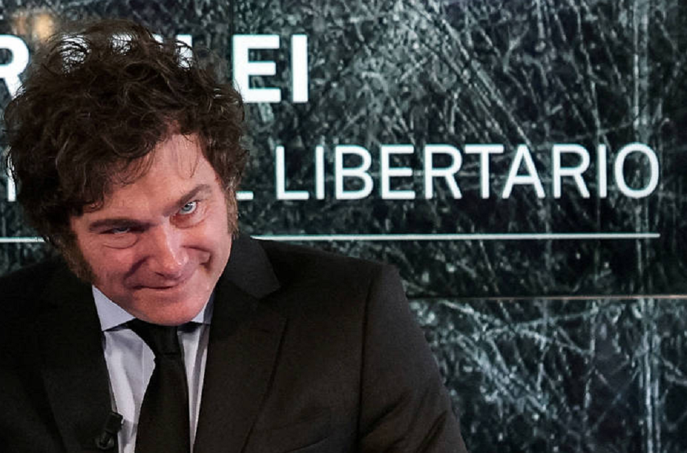 Javier Milei sorrindo com a cabeça abaixada