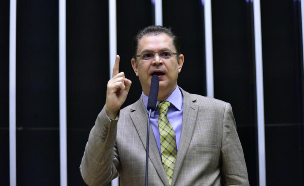 Deputado federal Sóstenes Cavalcante (PL-RJ) falando e gesticulando de terno e gravata, com expressão séria e óculos