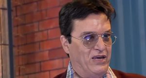 Nahim de óculos, falando e olhando para o lado com expressão séria