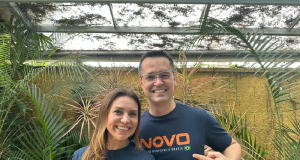 Fernanda Dallagnol e Deltan Dallagnol sorrindo para foto com camisa do Partido Novo