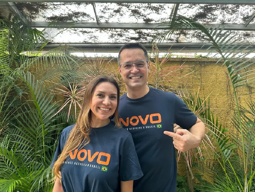 Fernanda Dallagnol e Deltan Dallagnol sorrindo para foto com camisa do Partido Novo