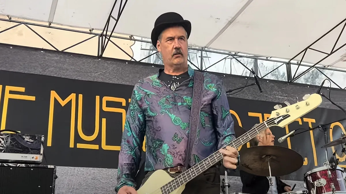 Ex-baixista do Nirvana, Krist Novoselic, sério, cantando no palco