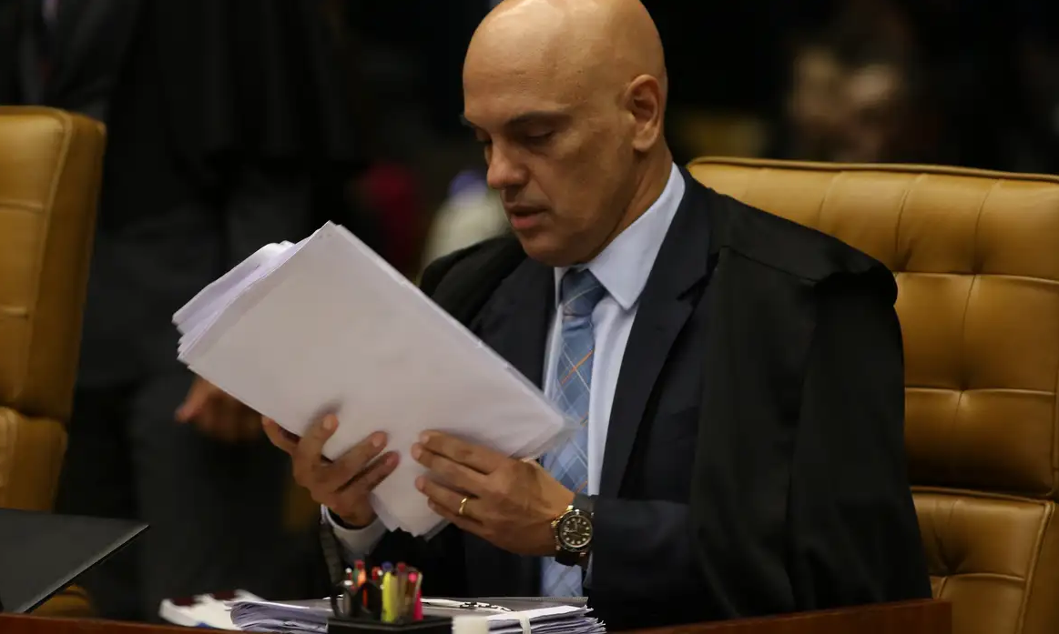 O ministro Alexandre de Moraes, do Supremo Tribunal Federal (STF) lendo papel com expressão séria