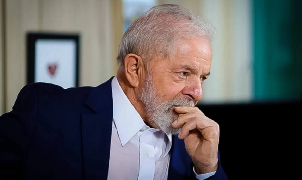 Lula com expressão pensativa e mão na boca