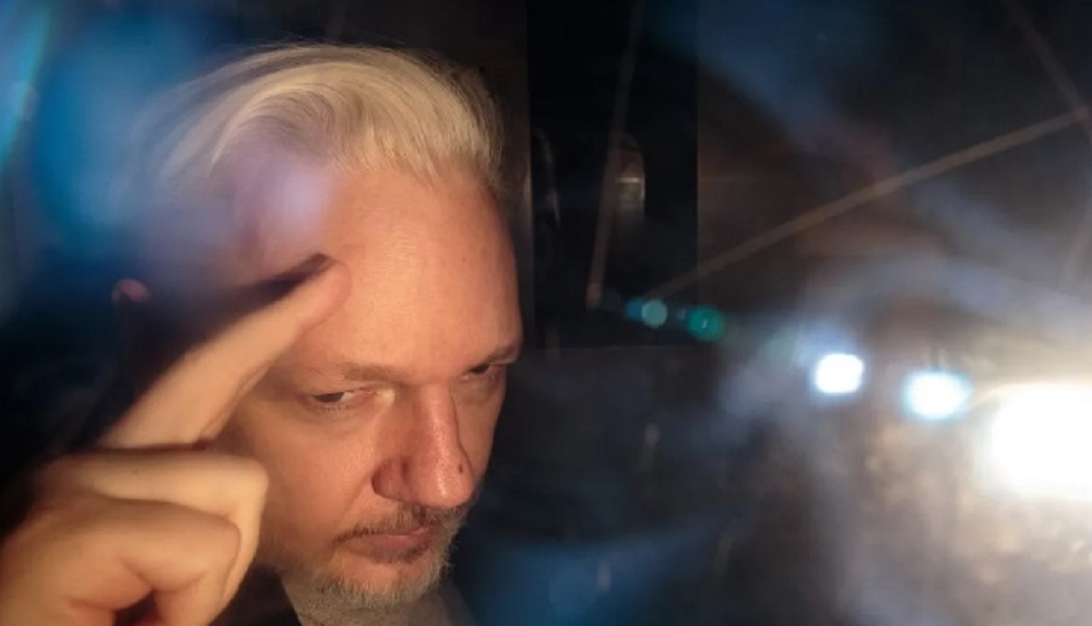 Julian Assange, fundador do WikiLeaks, dentro do carro, sério, acenando