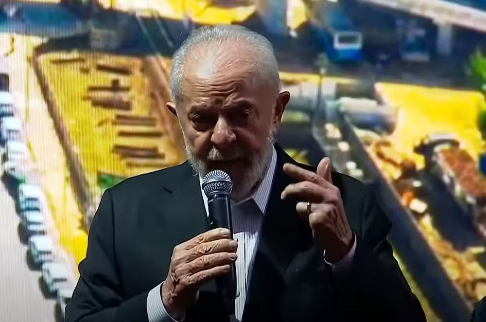 O presidente Luiz Inácio Lula da Silva (PT) falando em microfone e gesticulando, de terno e gravata