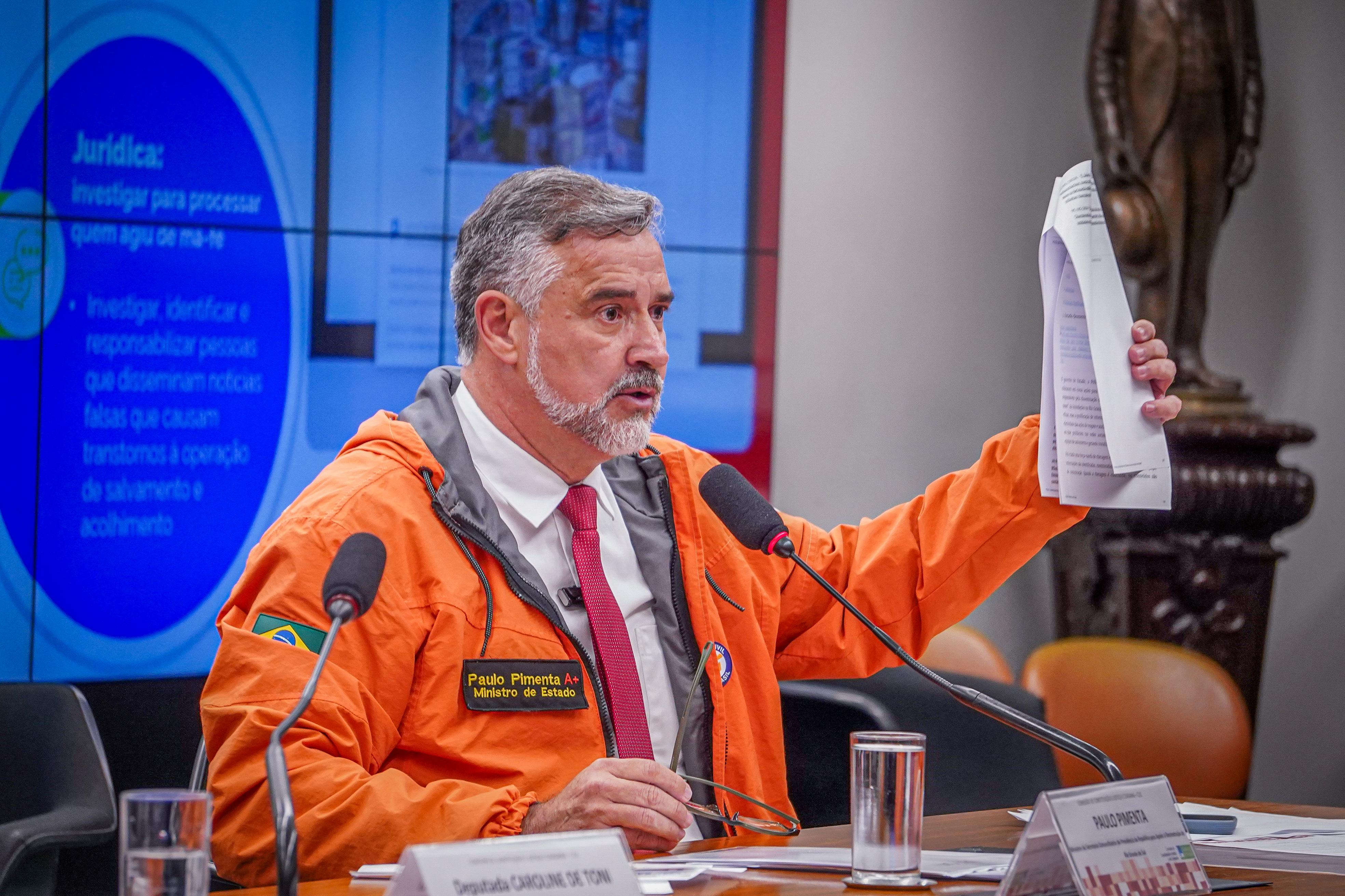 Paulo Pimenta falando e mostrando papel, de perfil