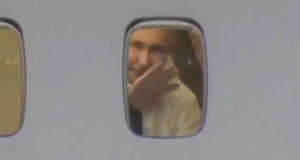 Vladimir Putin acenando em janela de avião