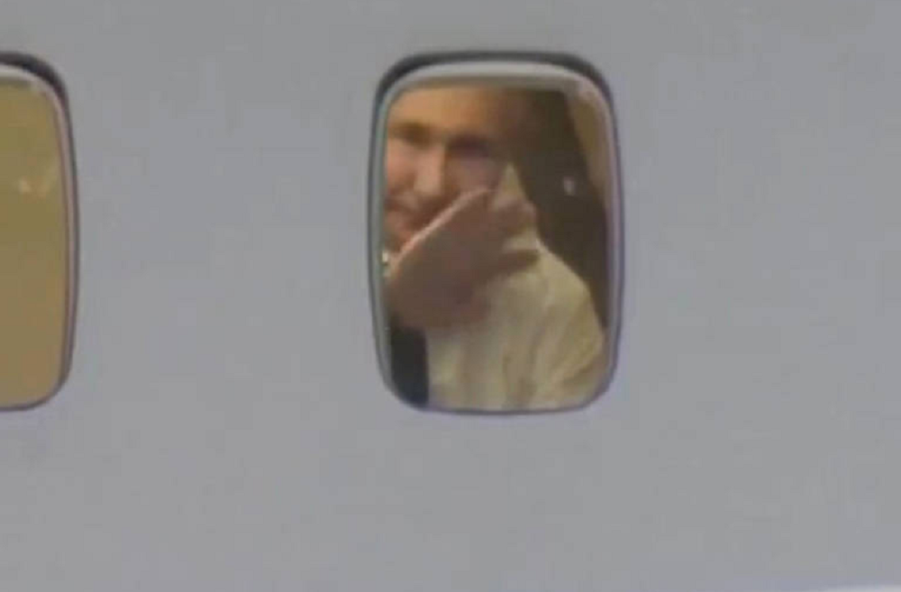 Vladimir Putin acenando em janela de avião