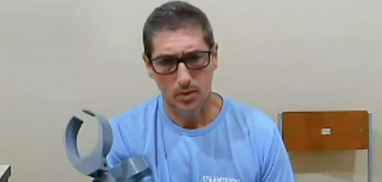 Ronnie Lessa de camiseta preta e óculos, falando cabisbaixo