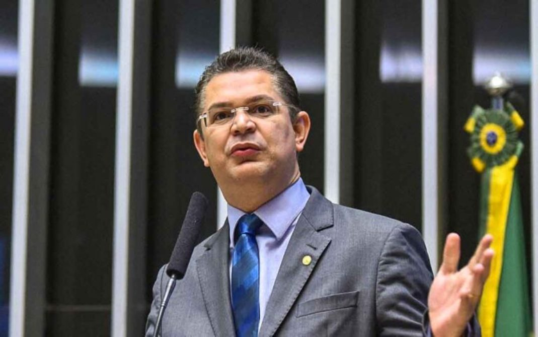 O deputado Sóstenes Cavalcante falando em microfone e olhando para o lado com expressão séria