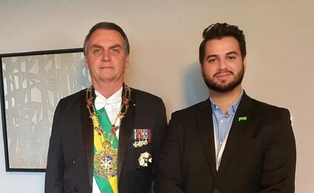 Jair Bolsonaro (PL) e seu ex-assessor, Filipe Martins, lado a lado, ambos sérios