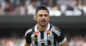 Willian Bigode correndo em campo com a camisa do Santos e expressão ofegante