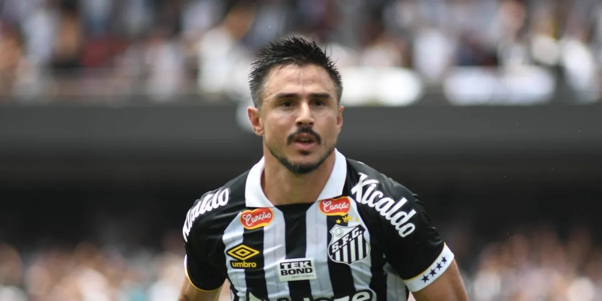 Willian Bigode correndo em campo com a camisa do Santos e expressão ofegante