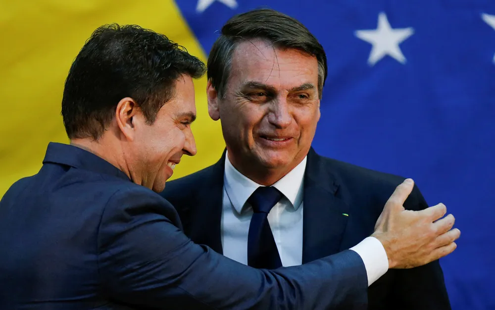 Alexandre Ramagem e Jair Bolsonaro sorrindo e se cumprimentando