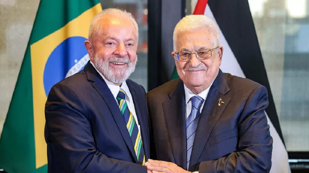 Lula com o presidente palestino Mahmud Abbas em evento, ambos sorrindo em aperto de mãos