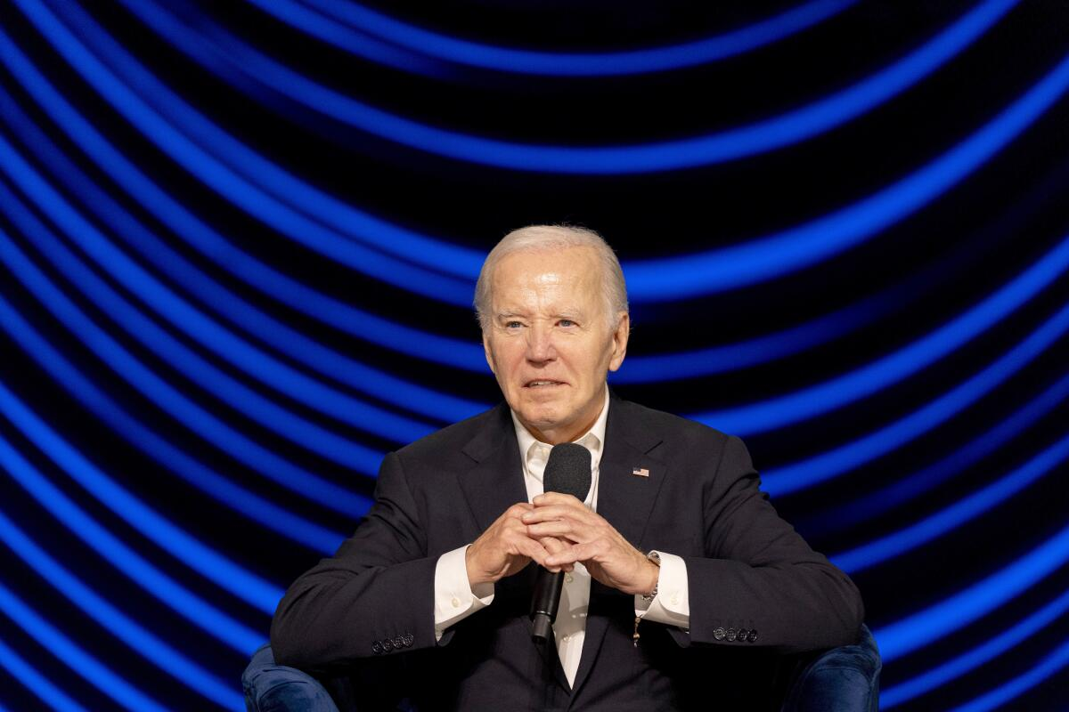 Joe Biden segurando microfone com expressão confusa