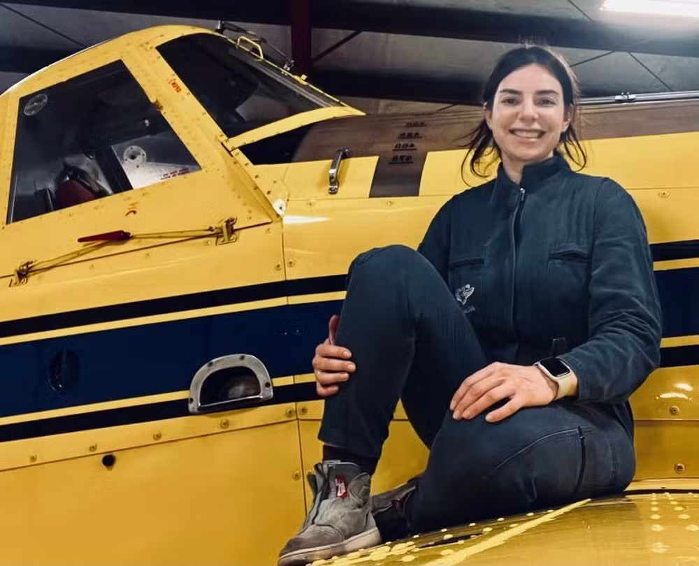 Juliana Turchetti sentada e sorrindo em avião amarelo