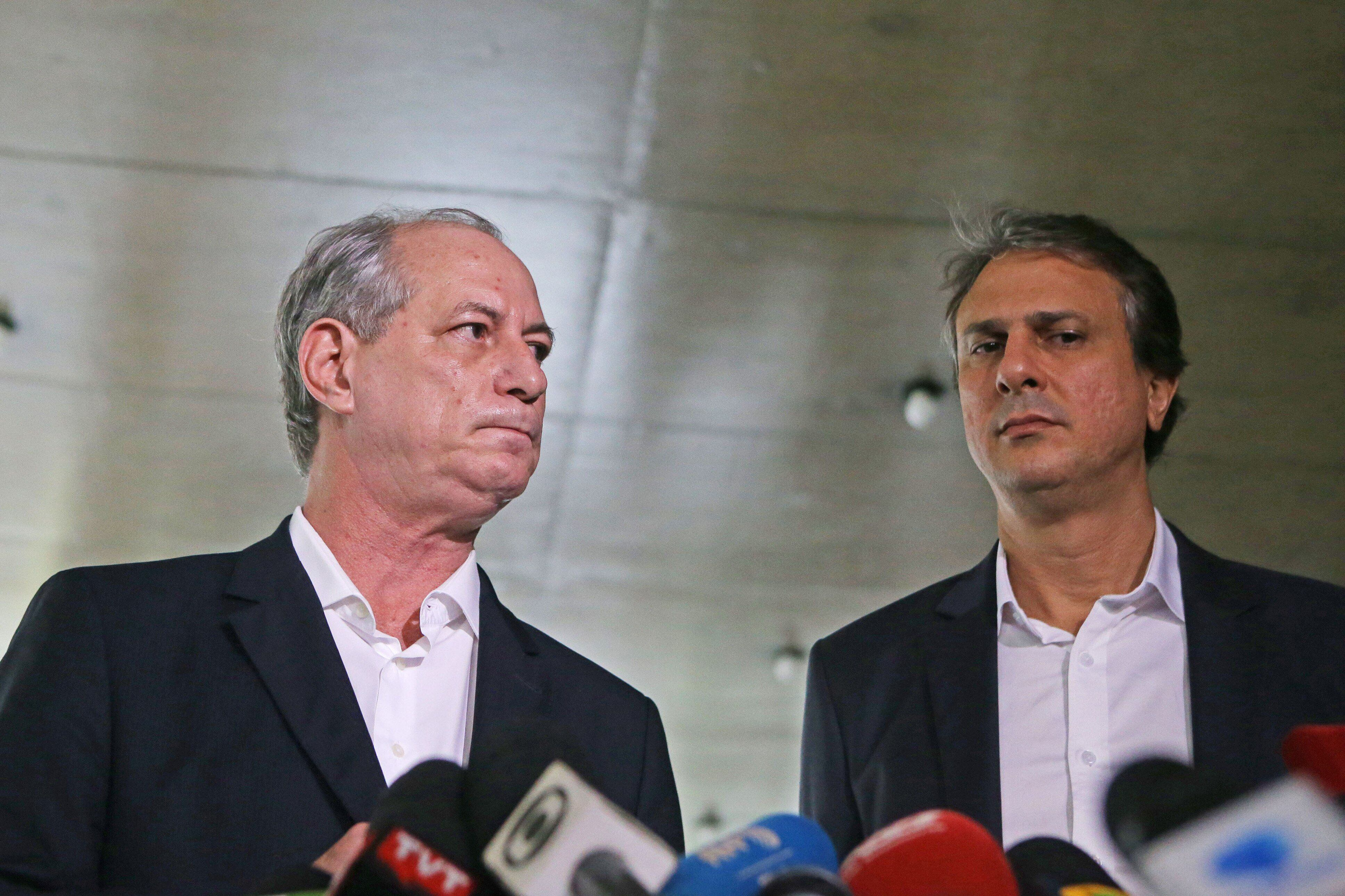 Ciro Gomes e Camilo Santana lado a lado, ambos sérios, perto de microfones