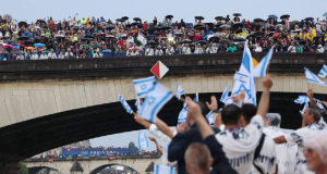 Pessoas levantando pequenas bandeiras de Israel perto do rio Sena