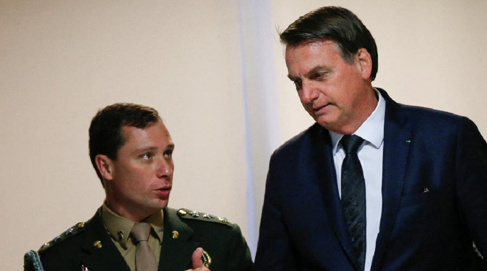 Mauro Cid e Jair Bolsonaro conversando, sérios